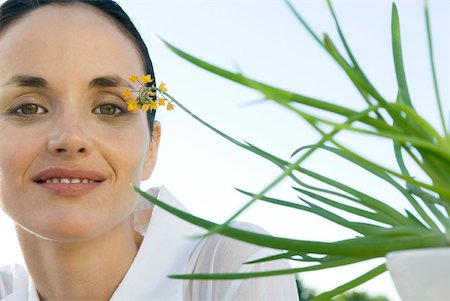 Woman with plant, smiling at camera Stock Photo - Premium Royalty-Free, Code: 633-02128726