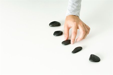 Hand arranging pebbles Stock Photo - Premium Royalty-Free, Code: 633-02128723