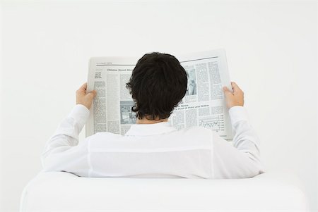 Man sitting in armchair, reading newspaper, rear view Stock Photo - Premium Royalty-Free, Code: 633-02128771