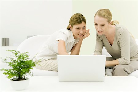 simsearch:633-02231704,k - Two women looking at laZSop computer together, smiling Foto de stock - Sin royalties Premium, Código: 633-02128792