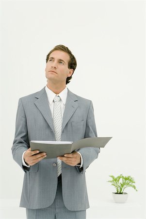 simsearch:695-03377755,k - Businessman holding document, looking up Stock Photo - Premium Royalty-Free, Code: 633-02128803