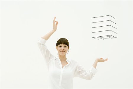 Woman with arms raised, hands underneath and to the side of box in midair, smiling at camera Stock Photo - Premium Royalty-Free, Code: 633-02231767