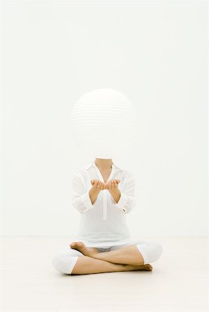 spheres - Woman sitting cross-legged on the ground, paper lantern floating in front of her face Stock Photo - Premium Royalty-Free, Code: 633-02231769