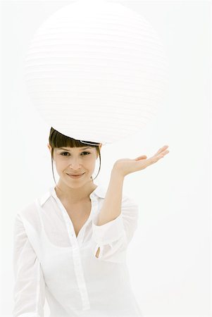 Woman looking underneath paper lantern, smiling at camera Stock Photo - Premium Royalty-Free, Code: 633-02231770