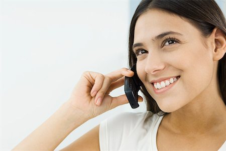 simsearch:632-02745019,k - Woman using cell phone, looking up and smiling Stock Photo - Premium Royalty-Free, Code: 633-02231793