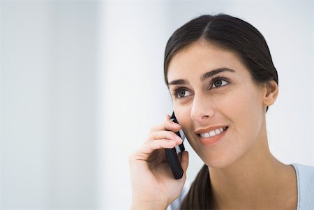 simsearch:695-03380514,k - Woman talking on cell phone, smiling and looking away Fotografie stock - Premium Royalty-Free, Codice: 633-02231849