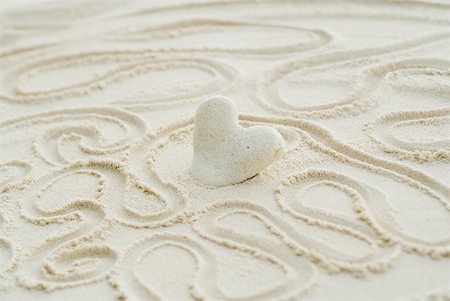 En forme de coeur corail coincé dans le sable, entourée par des lignes ondulées Photographie de stock - Premium Libres de Droits, Code: 633-02345749