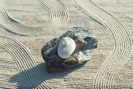 simsearch:633-02417737,k - Stones stacked on top of driftwood on raked sand Fotografie stock - Premium Royalty-Free, Codice: 633-02345740