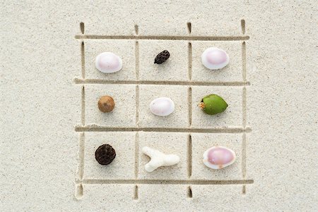 simsearch:633-02345735,k - Seashells, coral and nuts arranged on grid drawn in sand, close-up Foto de stock - Royalty Free Premium, Número: 633-02345764