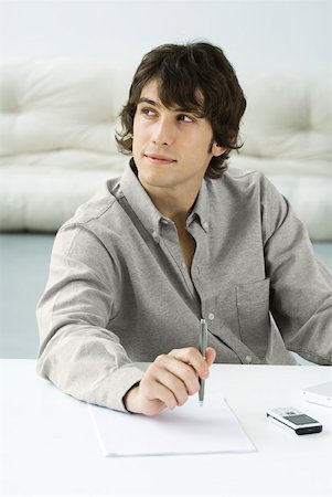 daydreamer man - Man holding pen above paper, looking away Stock Photo - Premium Royalty-Free, Code: 633-02345859