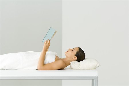 simsearch:633-02128630,k - Woman wrapped in towel, lying on massage table, holding book, eyes closed Foto de stock - Sin royalties Premium, Código: 633-02345931