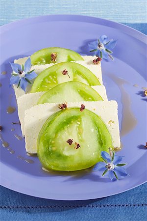 Alternating slices of green tomatoes and tofu arranged on a blue plate Foto de stock - Sin royalties Premium, Código: 633-02417383