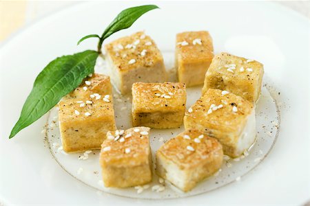 Fried tofu cubes arranged on plate, garnished with sesame seeds Foto de stock - Sin royalties Premium, Código: 633-02417408