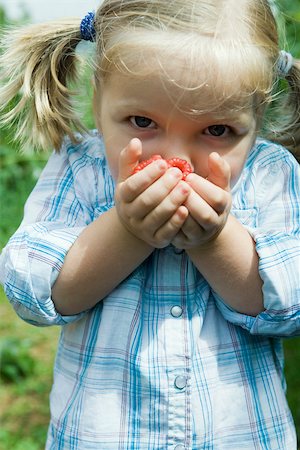 fruit smelling - Little girl holding handful of raspberries up to her face Stock Photo - Premium Royalty-Free, Code: 633-02418009