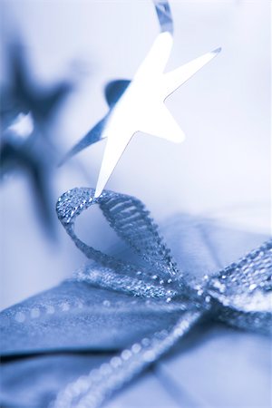 simsearch:632-06118213,k - Star ornament hanging over Christmas gift, close-up Fotografie stock - Premium Royalty-Free, Codice: 633-02418083