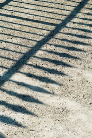 diagonal lines in photography - Shadow of wrought iron fence on gravel Foto de stock - Sin royalties Premium, Código: 633-02691223