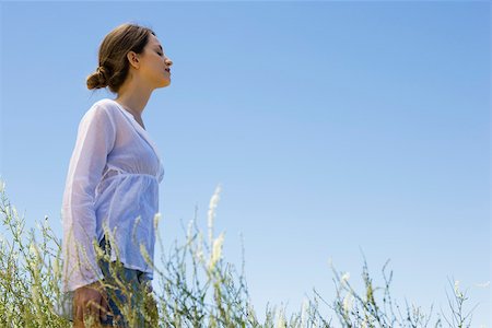 frische luft - Young Woman standing in hohem Gras, Augen geschlossen, seitliche Ansicht Stockbilder - Premium RF Lizenzfrei, Bildnummer: 633-03194503