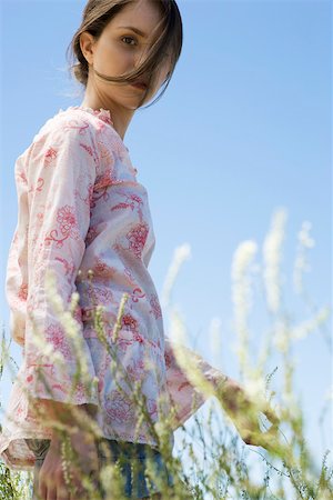 par-dessus l'épaule - Jeune femme qui marche dans les herbes hautes, cheveux ébouriffés par brise Photographie de stock - Premium Libres de Droits, Code: 633-03194528