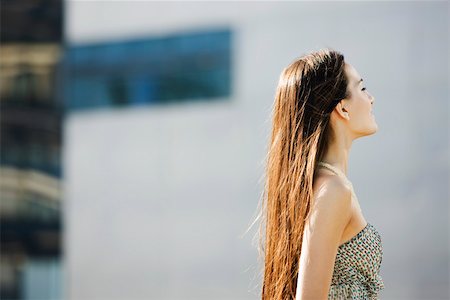 simsearch:633-01992711,k - Woman with long hair standing outdoors, eyes closed, side view Stock Photo - Premium Royalty-Free, Code: 633-03194579