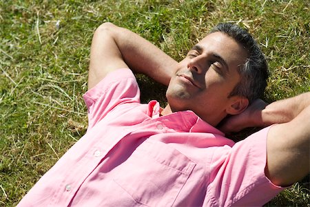 se détendre - Homme couché sur l'herbe avec les mains derrière la tête et les yeux fermés Photographie de stock - Premium Libres de Droits, Code: 633-03194685