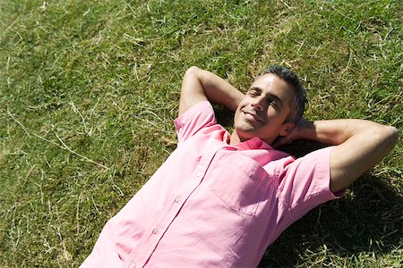 Man lying on grass with hands behind head and eyes closed Stock Photo - Premium Royalty-Free, Code: 633-03194686