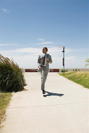 simsearch:632-03848155,k - Businessman running down sidewalk with expression of decisiveness Stock Photo - Premium Royalty-Free, Code: 633-03194787