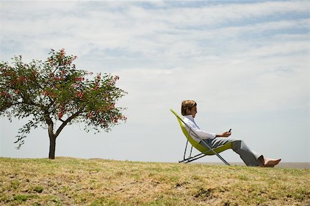 simsearch:633-03194783,k - Man relaxing outdoors looking at cell phone Stock Photo - Premium Royalty-Free, Code: 633-03194782