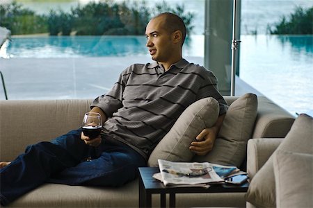 Man relaxing on sofa with glass of wine Stock Photo - Premium Royalty-Free, Code: 633-03444452