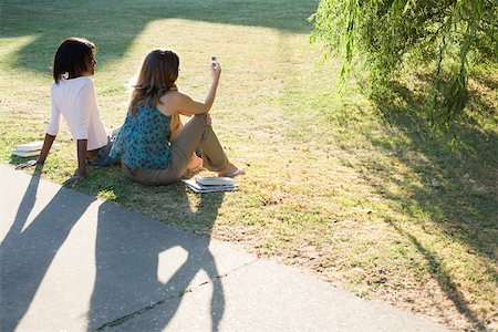 Friends sitting together on grass in park Stock Photo - Premium Royalty-Free, Code: 633-03444559