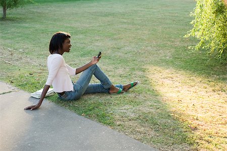 Young woman relaxing in park using cell phone Foto de stock - Sin royalties Premium, Código: 633-03444561