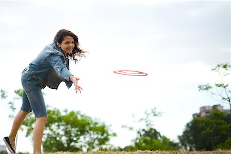 Woman throwing flying disc at park Stock Photo - Premium Royalty-Free, Code: 633-03444699