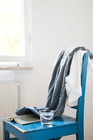 Clothes, glass of water, and book left on chair Stock Photo - Premium Royalty-Free, Code: 633-03444911
