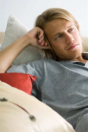 shoulder length hair - Man relaxing on pillows, looking away in thought Stock Photo - Premium Royalty-Free, Code: 633-03444953
