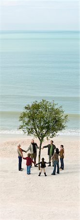 simsearch:633-03445015,k - Group of people holding hands in circle around solitary tree on beach Foto de stock - Sin royalties Premium, Código: 633-03444976