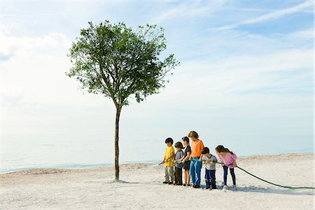 six - Ecology conceZS, children watering tree growing on beach Stock Photo - Premium Royalty-Free, Code: 633-03444999