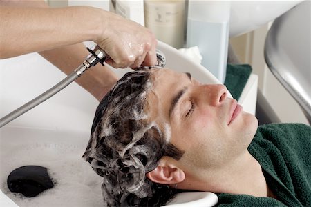 Young man having his hair  washed at a salon Stock Photo - Premium Royalty-Free, Code: 644-01435810