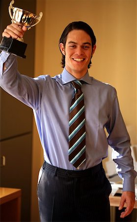 Young businessman holding trophy Stock Photo - Premium Royalty-Free, Code: 644-01435923