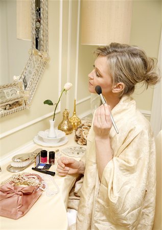 refining - Woman sitting at the dressing table and applying cosmetics Foto de stock - Sin royalties Premium, Código: 644-01436102