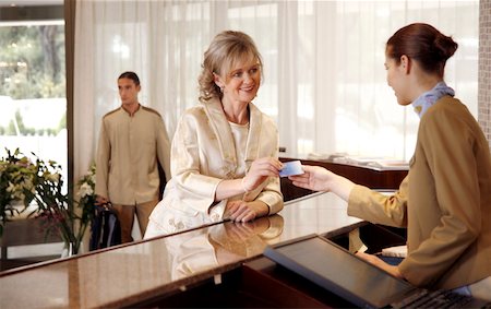 Woman checking in at the hotel reception desk Stock Photo - Premium Royalty-Free, Code: 644-01436201