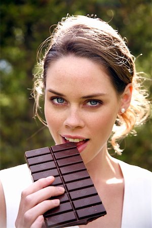 Young woman eating chocolate Stock Photo - Premium Royalty-Free, Code: 644-01436409