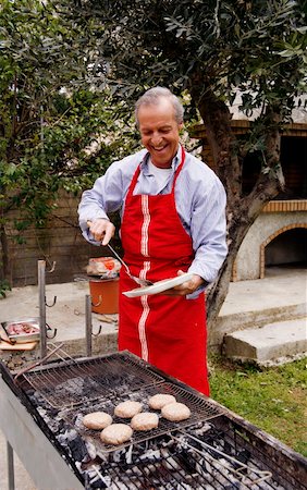 Mature man cooking food at a barbecue Foto de stock - Sin royalties Premium, Código: 644-01436424