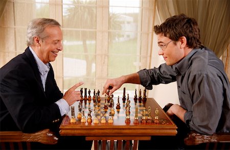 family playing board game - Mature man and younger man playing chess Stock Photo - Premium Royalty-Free, Code: 644-01436432