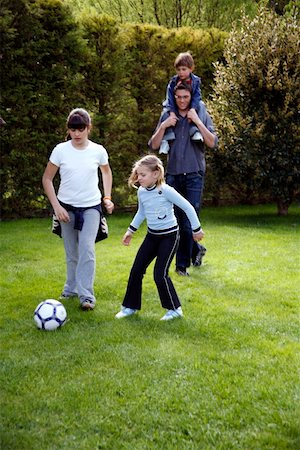 father and daughter playing football - Man and children playing soccer Stock Photo - Premium Royalty-Free, Code: 644-01436459