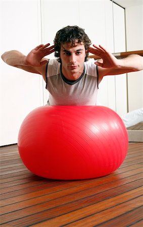 Young man performing a pilates exercise Stock Photo - Premium Royalty-Free, Code: 644-01436648