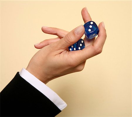 A woman holding a pair of blue dice Stock Photo - Premium Royalty-Free, Code: 644-01436717