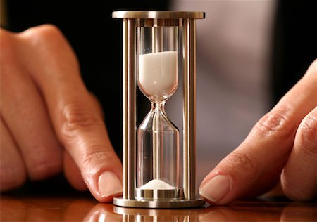 An hourglass held down with two fingers Foto de stock - Sin royalties Premium, Código: 644-01436783