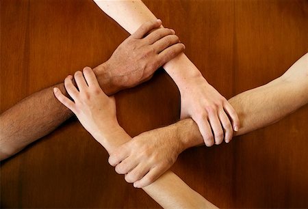 four human hands joined in unity - Four arms locked together at the wrists Stock Photo - Premium Royalty-Free, Code: 644-01436827