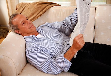 Mature man reading newspaper on couch Stock Photo - Premium Royalty-Free, Code: 644-01437199