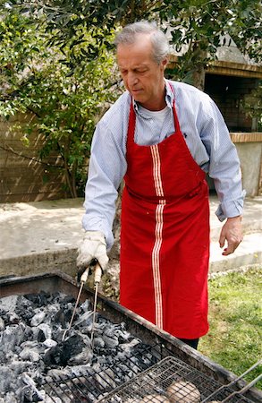 Mature man cooking food at a barbecue Foto de stock - Sin royalties Premium, Código: 644-01437201