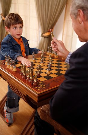 Mature man and little boy playing chess Stock Photo - Premium Royalty-Free, Code: 644-01437215